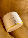 White jar with a label on a textured beige background